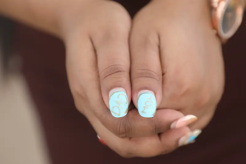 Pale blue nails with hand-lettered nail art