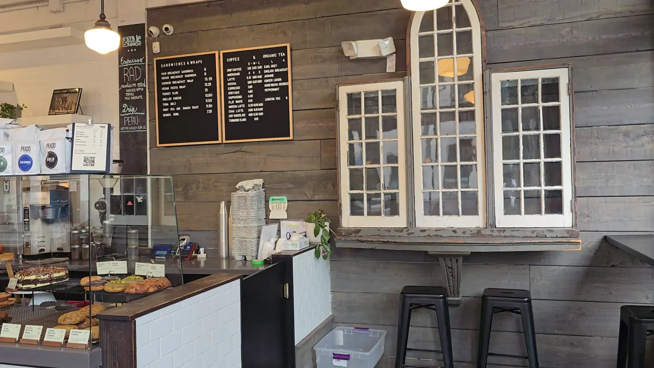 Inside a bakery: a counter with bread and pastries under hanging lights