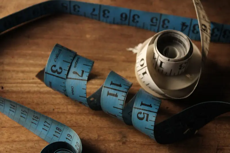 Blue tailor's measuring tapes on a wooden table